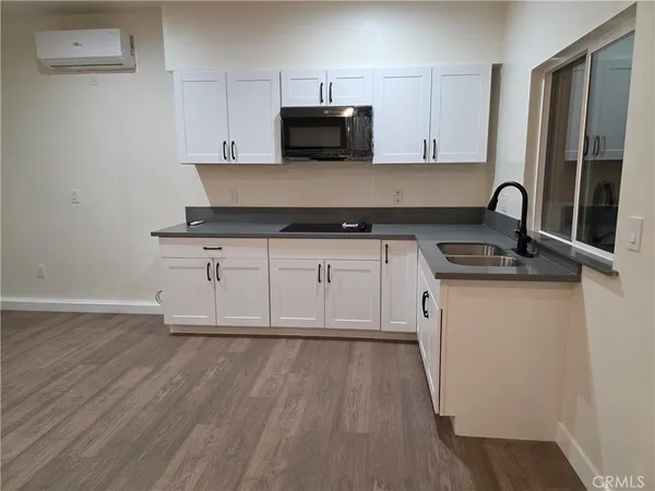a kitchen with granite countertop a stove and a wooden floor