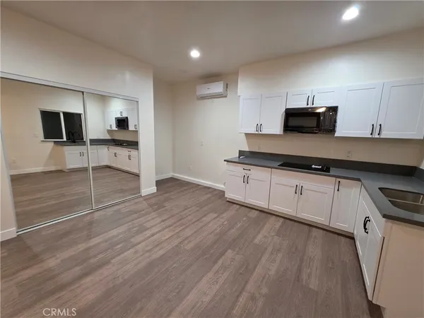 a kitchen with granite countertop a stove and cabinets