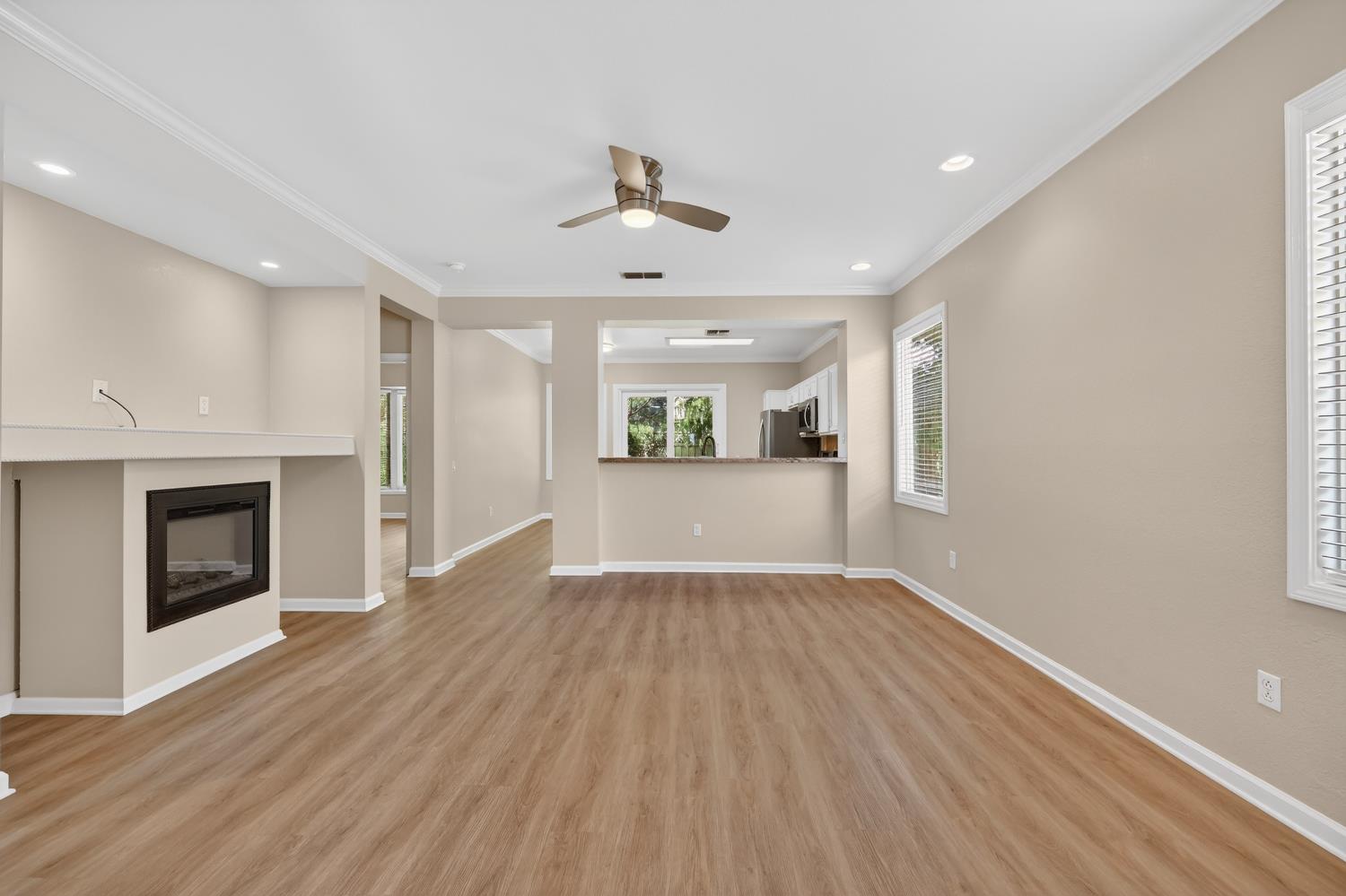 2272 Winding Way Lincoln, CA 95648 - Photo 5 of 46 an empty room with wooden floor fireplace and windows