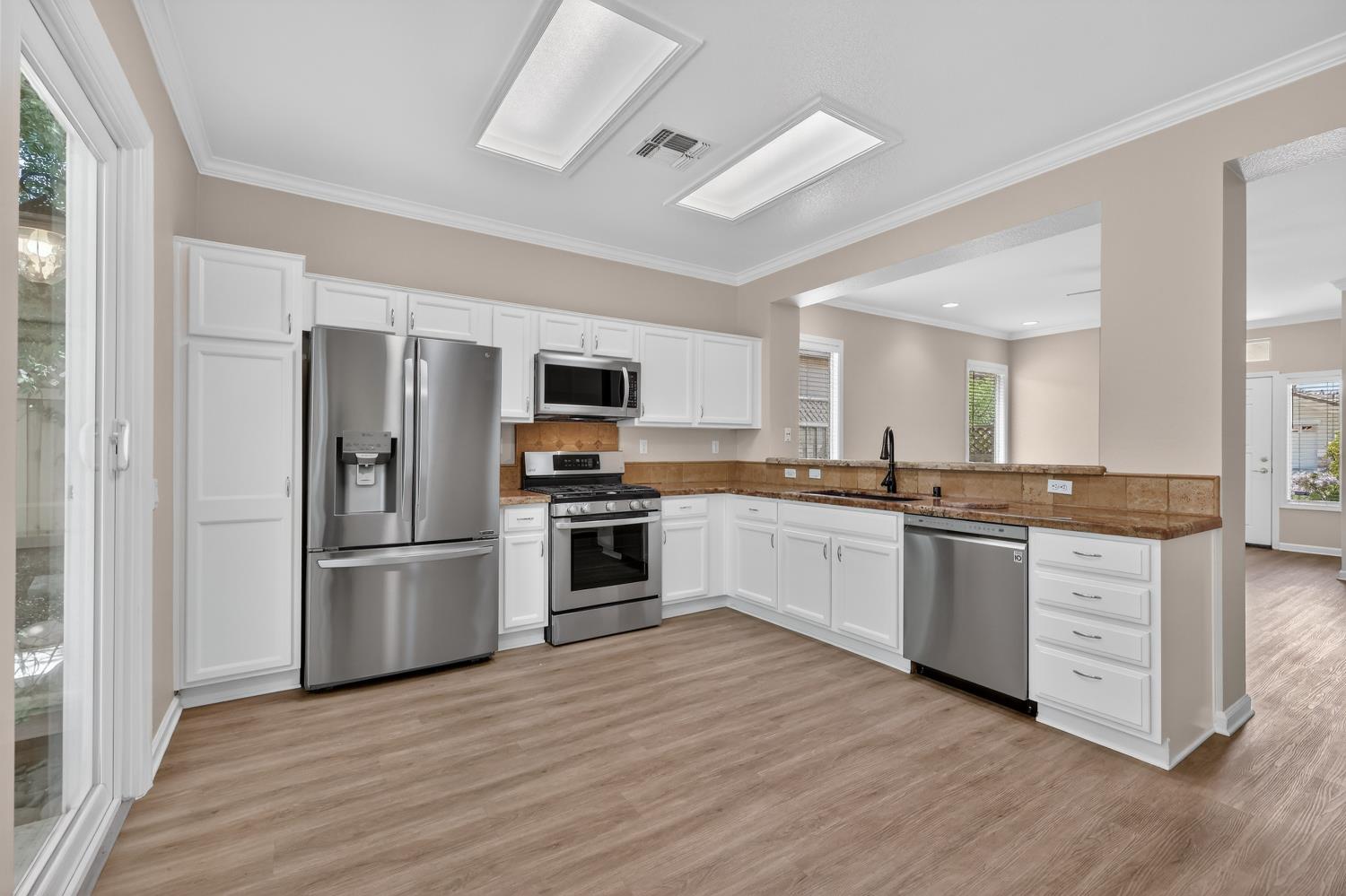2272 Winding Way Lincoln, CA 95648 - Photo 9 of 46 a kitchen with granite countertop a refrigerator and a stove top oven