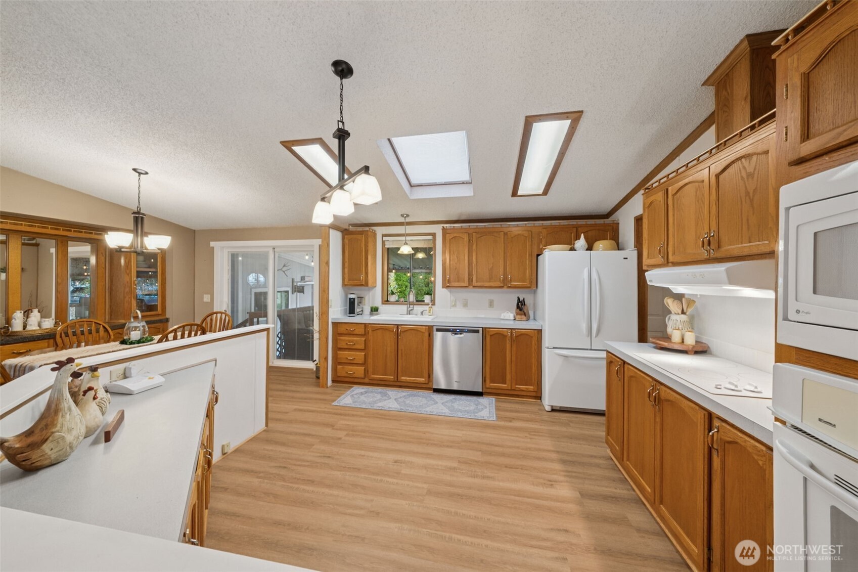 2350 Rincon Avenue Enumclaw, WA 98022 - Photo 11 of 31 a large kitchen with stainless steel appliances wooden floors and white cabinets