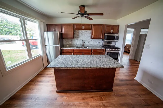 a kitchen with stainless steel appliances granite countertop a refrigerator a stove top oven a sink and dishwasher