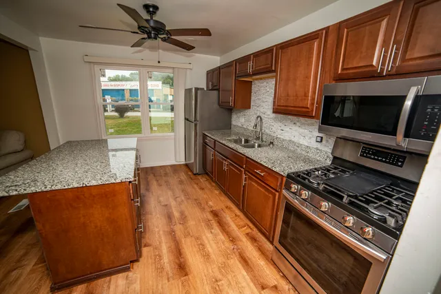 a large kitchen with wooden cabinets and a stove top oven