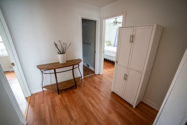 a view of a hallway with wooden floor and staircase