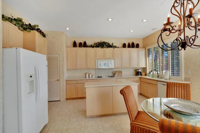 a kitchen with a refrigerator a sink dishwasher with a dining table and chairs