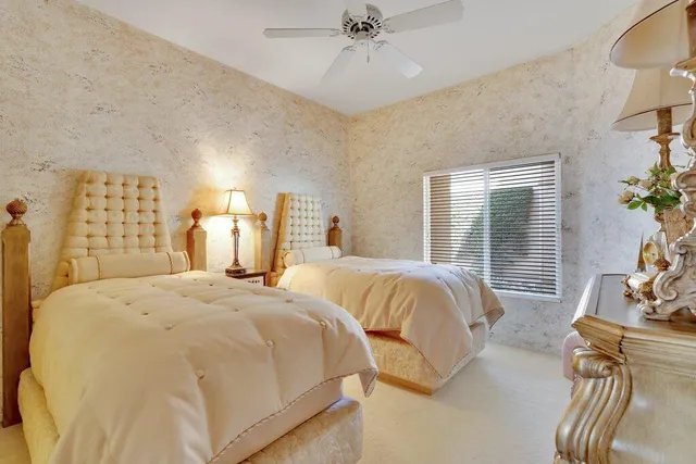 a spacious bedroom with two beds and potted plant