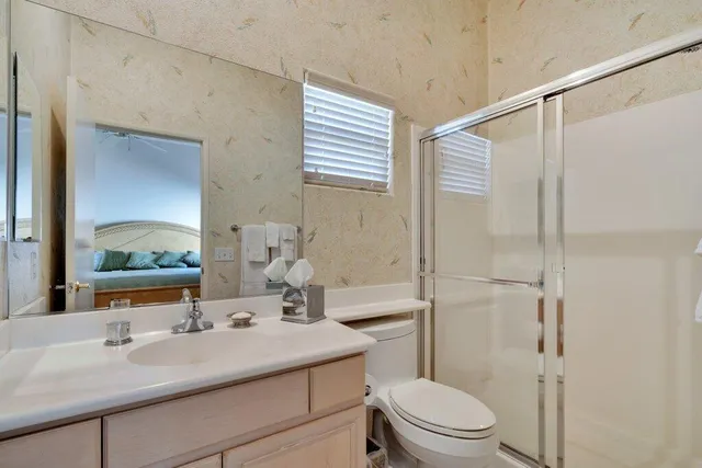 a bathroom with a sink toilet vanity and shower