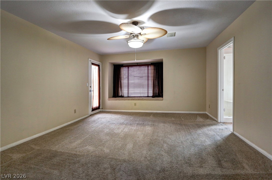 2108 Crestpoint Way Las Vegas, NV 89134 - Photo 13 of 27 A spacious room offers comfortable carpeting, a built-in window bench, and a practical ceiling fan.