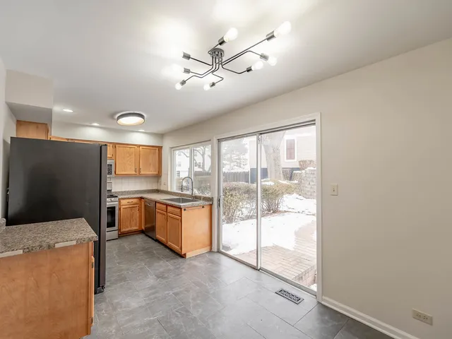 a open kitchen with kitchen island a large window a sink and a counter top space
