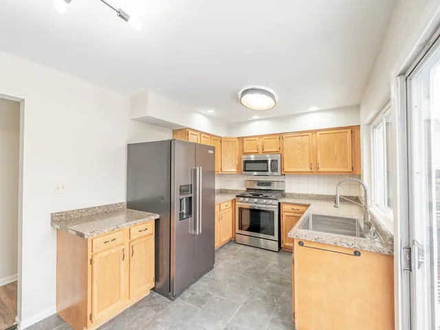 a kitchen with a refrigerator sink and stove top oven