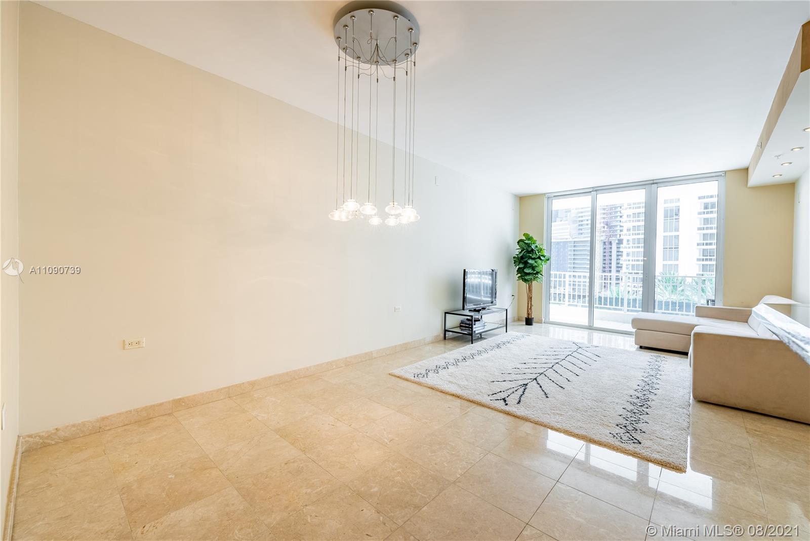 801 Brickell Key Boulevard, Unit 806 Miami, FL 33131 - Photo 2 of 20 a spacious bedroom with a bed a couch and large window