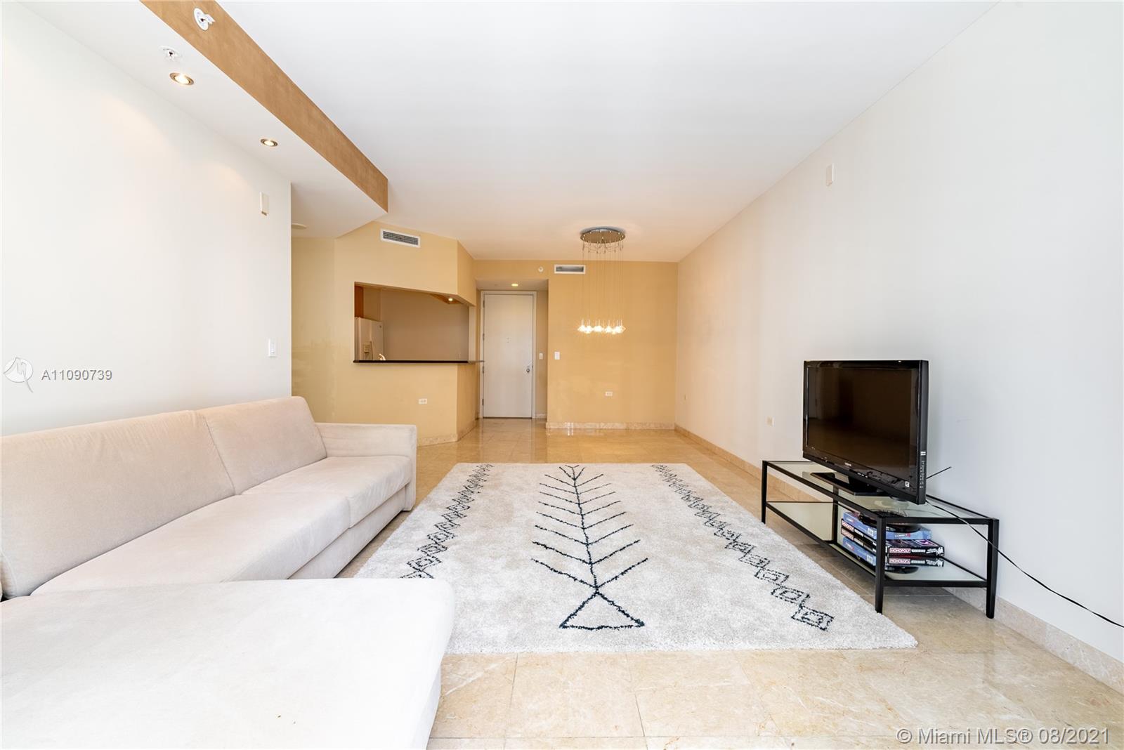 801 Brickell Key Boulevard, Unit 806 Miami, FL 33131 - Photo 14 of 20 a living room with a flat screen tv and a couch