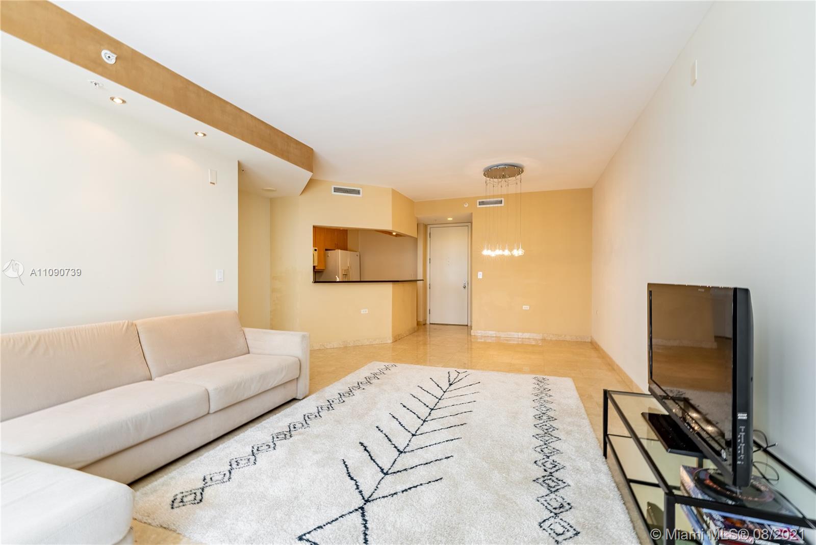 801 Brickell Key Boulevard, Unit 806 Miami, FL 33131 - Photo 15 of 20 a spacious bedroom with a bed and a flat screen tv