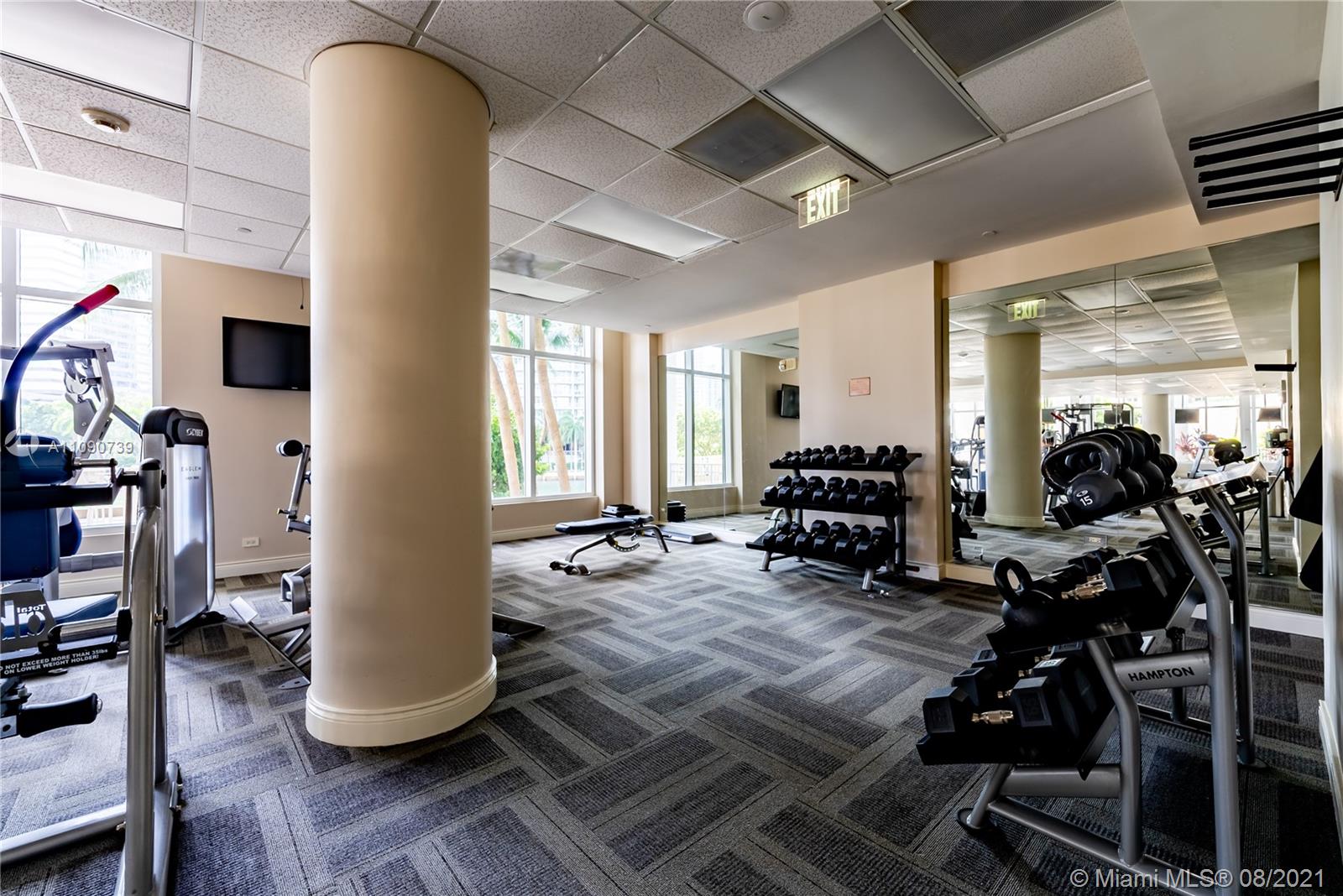 801 Brickell Key Boulevard, Unit 806 Miami, FL 33131 - Photo 18 of 20 a living room with furniture a couch and gym equipment