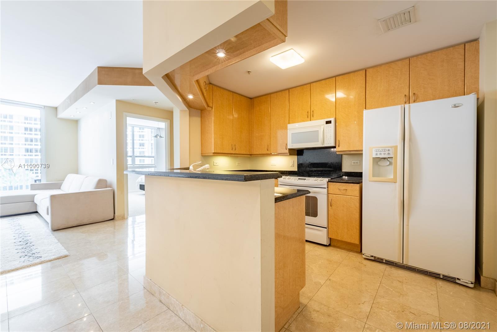 801 Brickell Key Boulevard, Unit 806 Miami, FL 33131 - Photo 3 of 20 a kitchen with kitchen island a counter top space a sink stainless steel appliances and cabinets