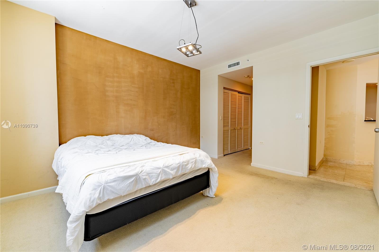 801 Brickell Key Boulevard, Unit 806 Miami, FL 33131 - Photo 9 of 20 a bed sitting in a bedroom next to a window