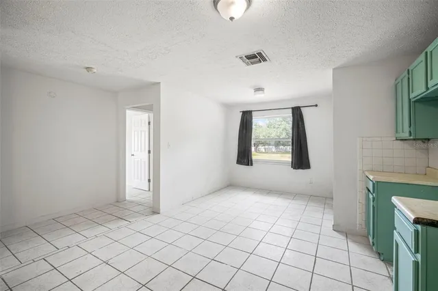 an empty room with a ceiling fan and window