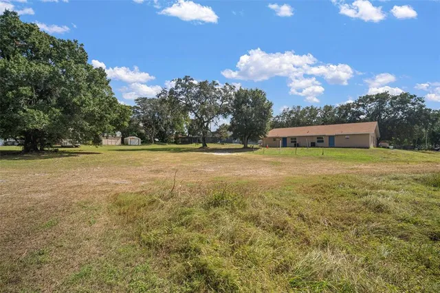 a view of a house with a yard garage and tree