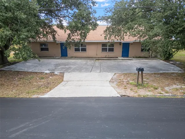 an aerial view of residential building with yard and mountain view in back