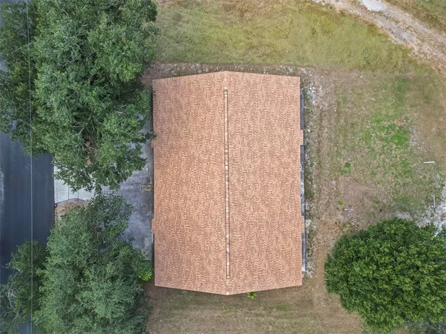 an aerial view of residential houses with outdoor space and ocean view