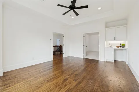 a view of empty room with wooden floor and ceiling fan