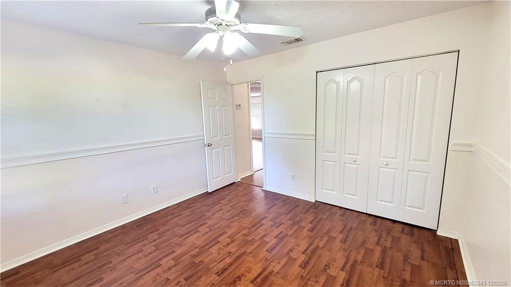 2149 Southeast Dolphin Road Port St. Lucie, FL 34952 - Photo 14 of 25 an empty room with wooden floor closet fan and windows