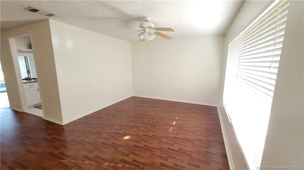 2149 Southeast Dolphin Road Port St. Lucie, FL 34952 - Photo 5 of 25 a view of a room with wooden floor and a ceiling fan