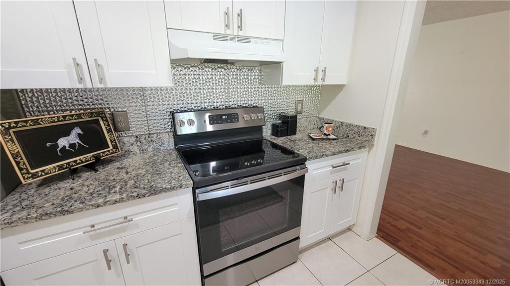 2149 Southeast Dolphin Road Port St. Lucie, FL 34952 - Photo 10 of 25 a kitchen with granite countertop cabinets stainless steel appliances and wooden floor