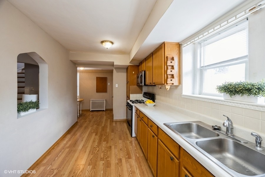 1309 Maple Avenue Berwyn, IL 60402 - Photo 4 of 17 a kitchen with a sink a counter top space and stainless steel appliances wooden floor