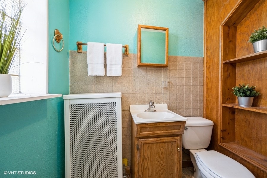 1309 Maple Avenue Berwyn, IL 60402 - Photo 9 of 17 a bathroom with a toilet a sink and mirror