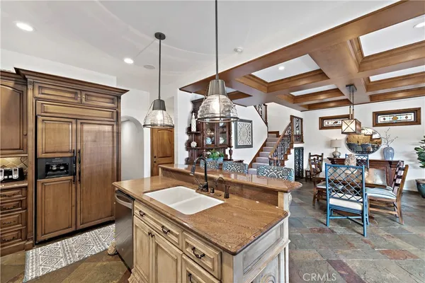 a kitchen with stainless steel appliances kitchen island granite countertop a stove a sink and a chandelier