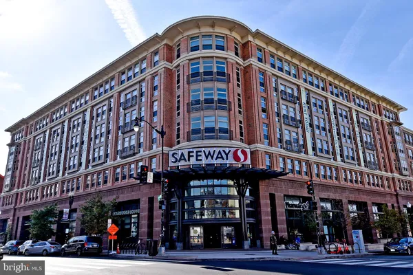 a front view of multi story building with retail shops