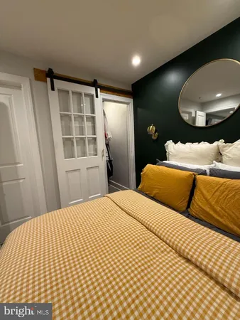a bedroom with a bed and a large mirror