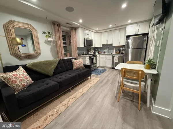 a living room with a couch and a refrigerator