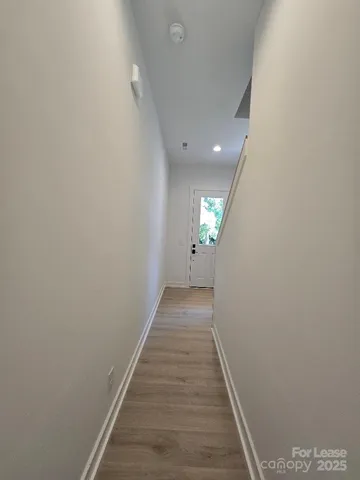 a view of a hallway with wooden floor