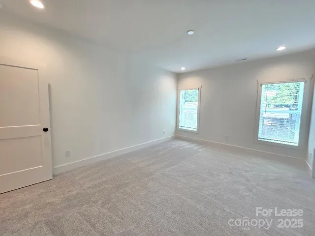 a view of an empty room with a window and closet area