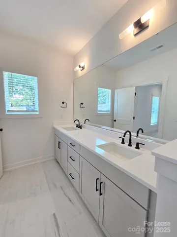 a bathroom with double sink and a mirror