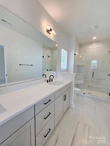 a spacious bathroom with double sink and a mirror