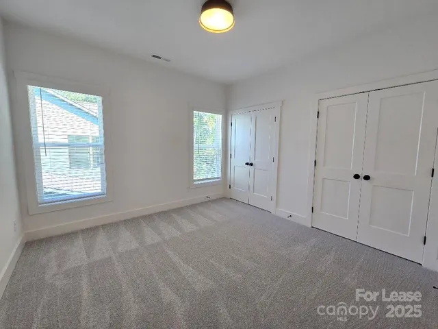 an empty room with windows and closet