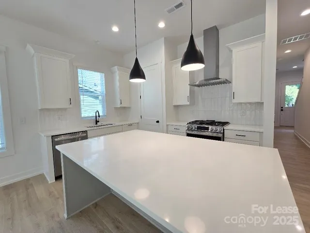 a large kitchen with stainless steel appliances a large counter top