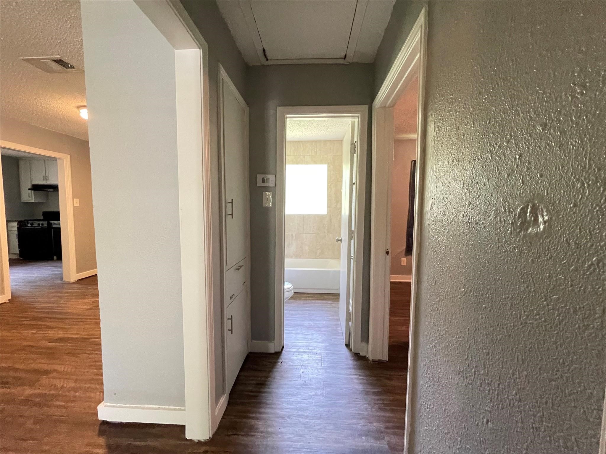 5213 Anzio Road Houston, TX 77033 - Photo 14 of 20 a view of a hallway with wooden floor
