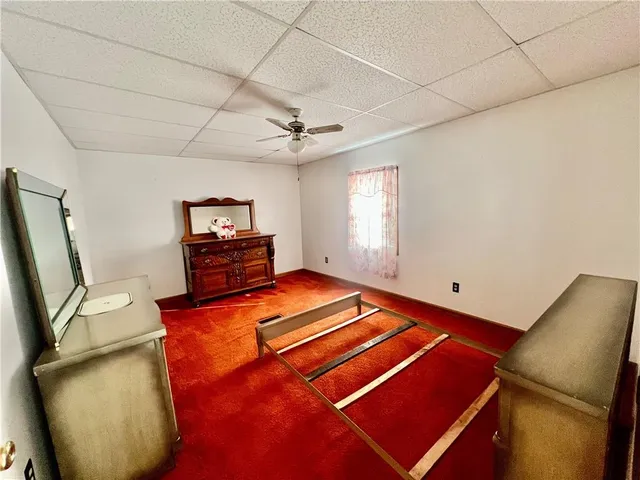 a bed sitting in a spacious bedroom next to a window