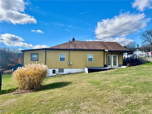 a view of an house with backyard space and balcony
