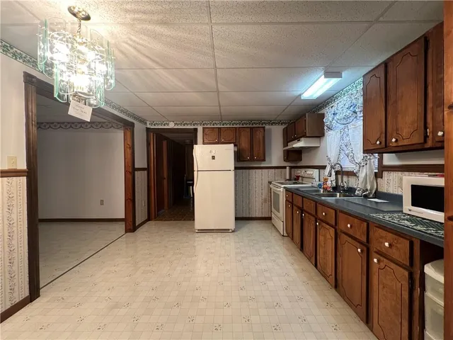 a kitchen with stainless steel appliances granite countertop a refrigerator a stove a sink dishwasher and wooden cabinets