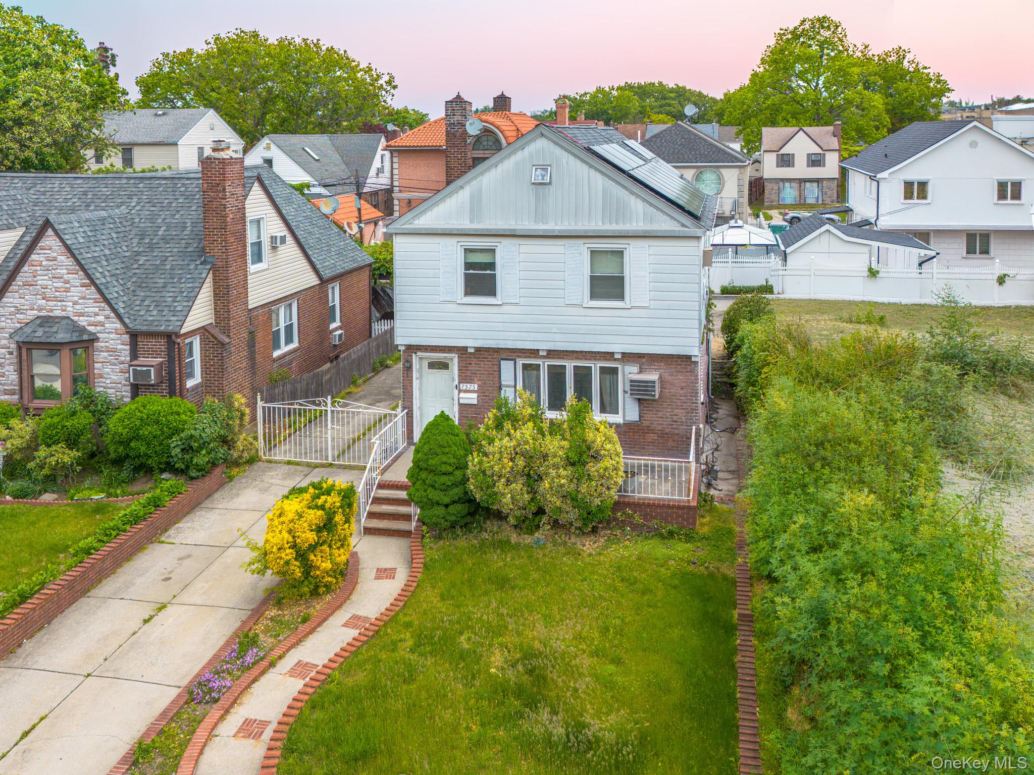 75-75 180th Street Queens, NY 11366 - Photo 1 of 48 a front view of a house with garden