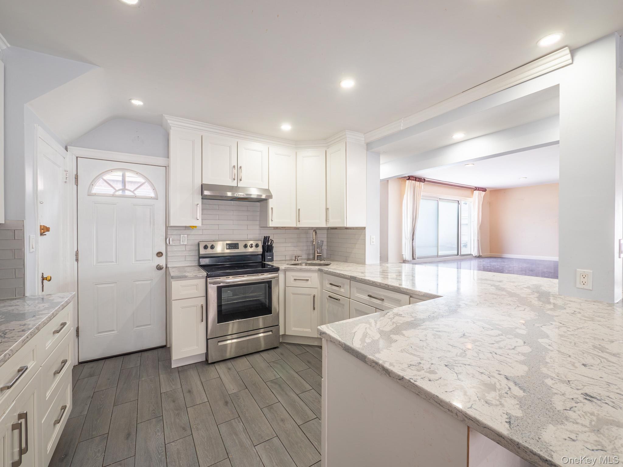 75-75 180th Street Queens, NY 11366 - Photo 11 of 48 a kitchen with a stove a sink and a refrigerator