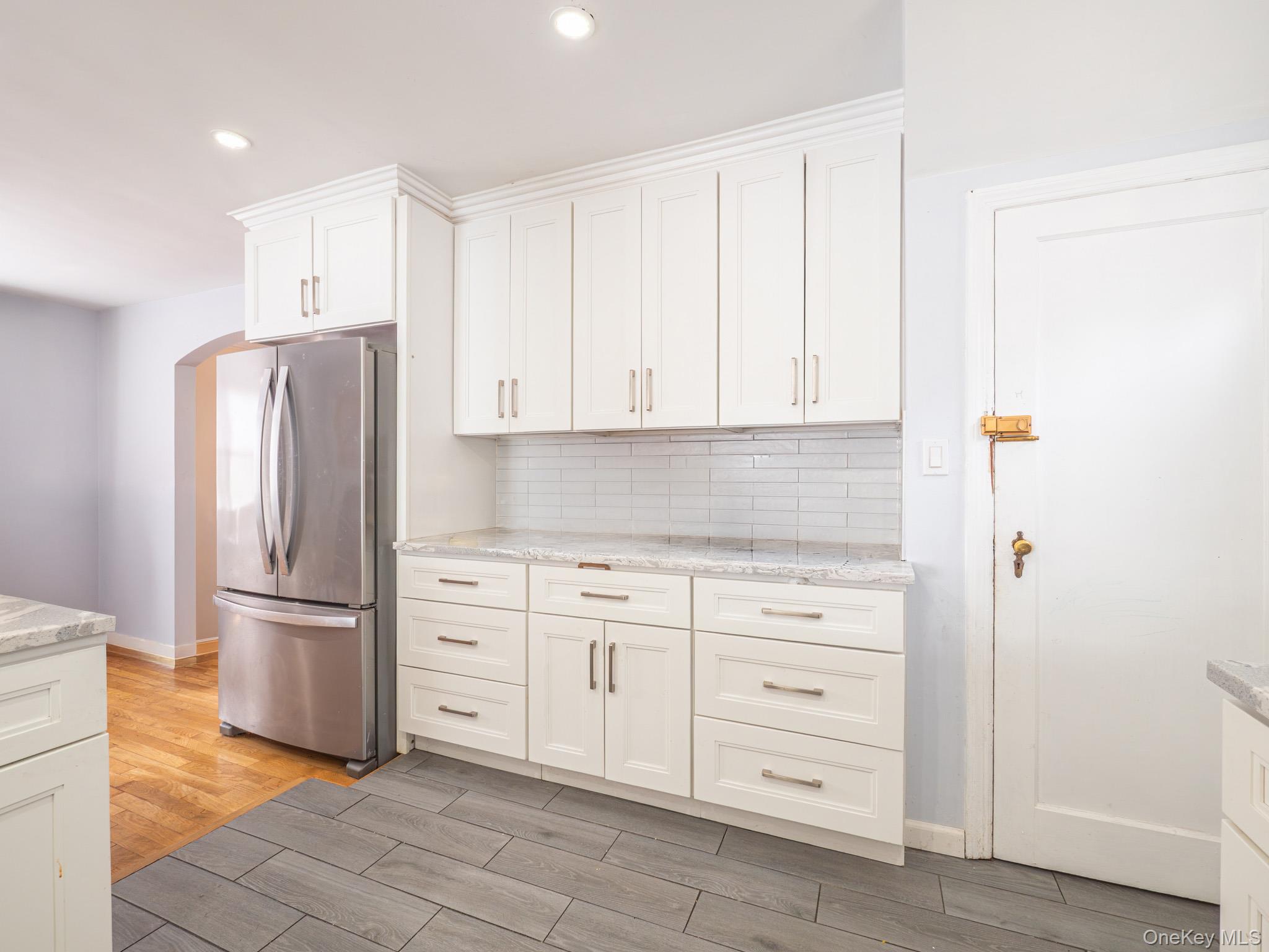 75-75 180th Street Queens, NY 11366 - Photo 13 of 48 a kitchen with stainless steel appliances white cabinets and a refrigerator