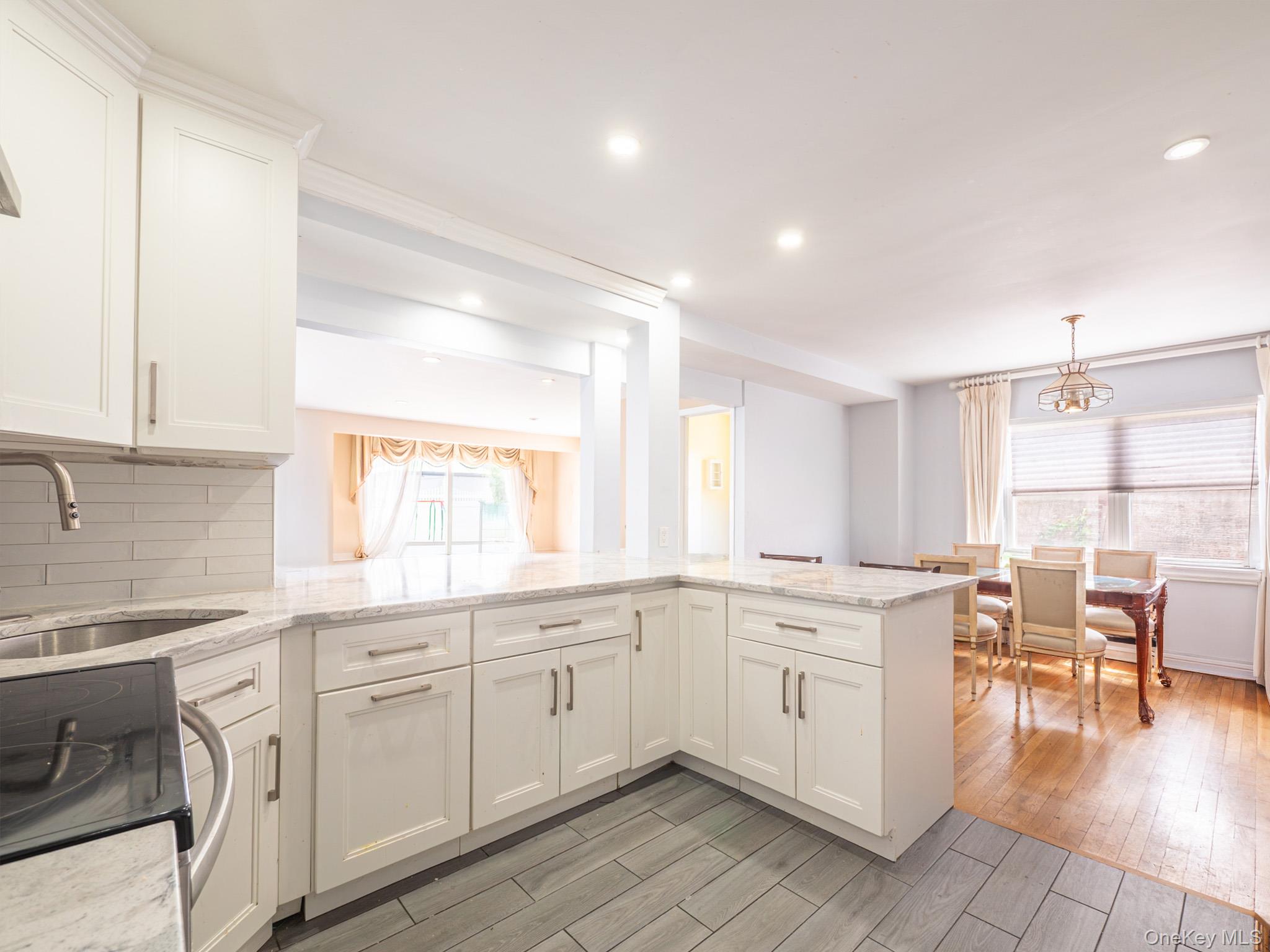 75-75 180th Street Queens, NY 11366 - Photo 14 of 48 a kitchen with a sink window and chairs
