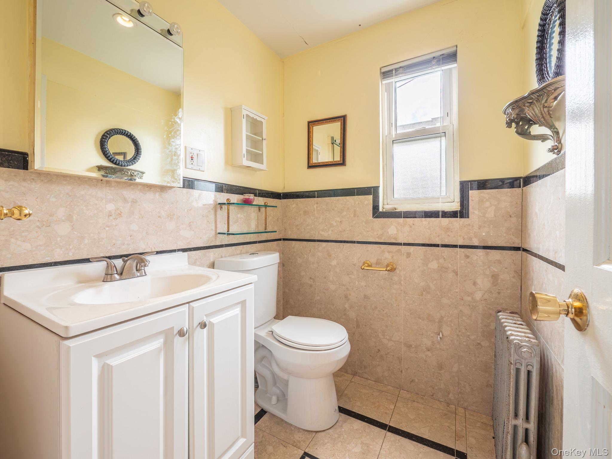 75-75 180th Street Queens, NY 11366 - Photo 15 of 48 a bathroom with a sink a toilet and a mirror