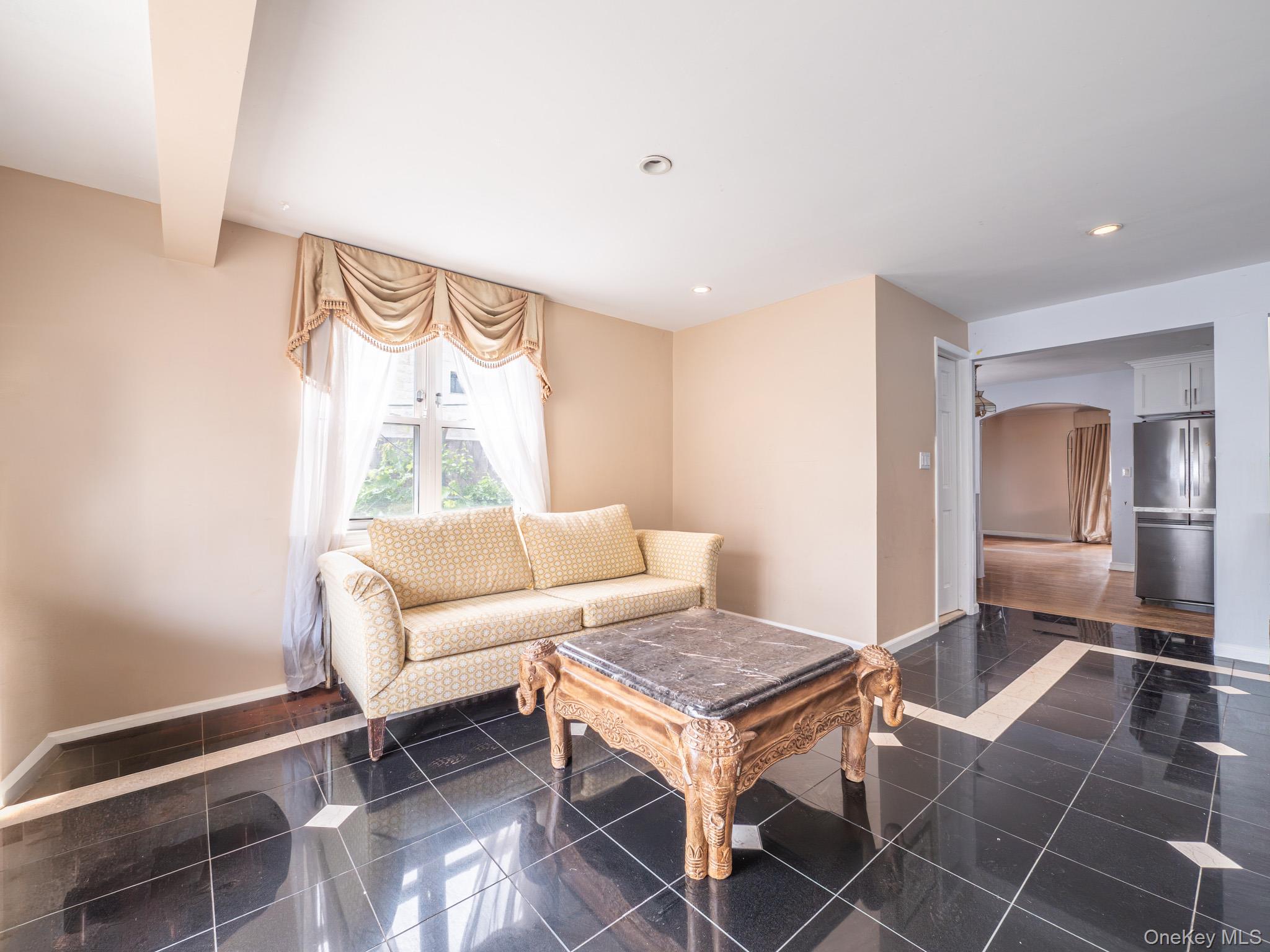 75-75 180th Street Queens, NY 11366 - Photo 17 of 48 a living room with a couch and a table in it